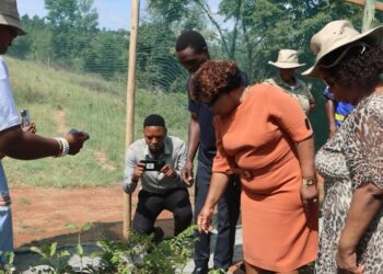The Minister inspects one of the young plants during the handover of the “Planting for the Future” project in Hhukwini