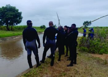 Police scuba divers from the Royal Eswatini Police Service retrieve the body of an eight year old boy from a water canal in Othandweni during a search operation conducted with officers from Siphofaneni on Friday morning.