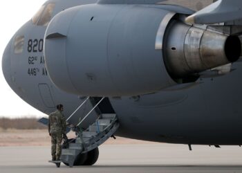 A United States soldier stands guard beside a military aircraft during the transfer of deported third country nationals from the United States to the Kingdom of Eswatini. Photo by Christian Torres/Anadolu/Getty Images/File