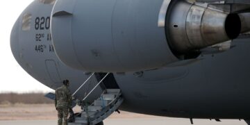 A United States soldier stands guard beside a military aircraft during the transfer of deported third country nationals from the United States to the Kingdom of Eswatini. Photo by Christian Torres/Anadolu/Getty Images/File