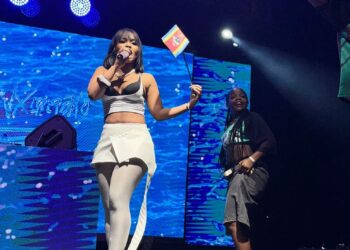 Zee Nxumalo waves Eswatini flag at Farmers Market